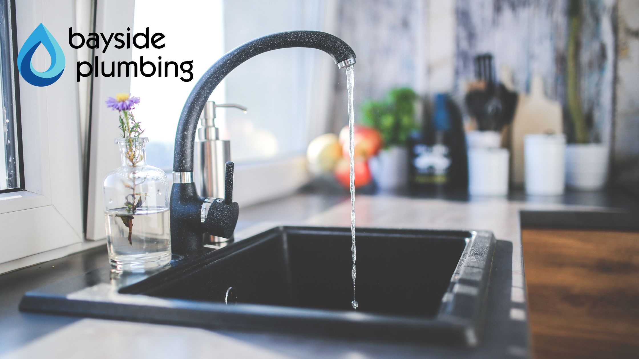 Modern kitchen sink with running water, representing professional plumbing services by Bayside Plumbing.