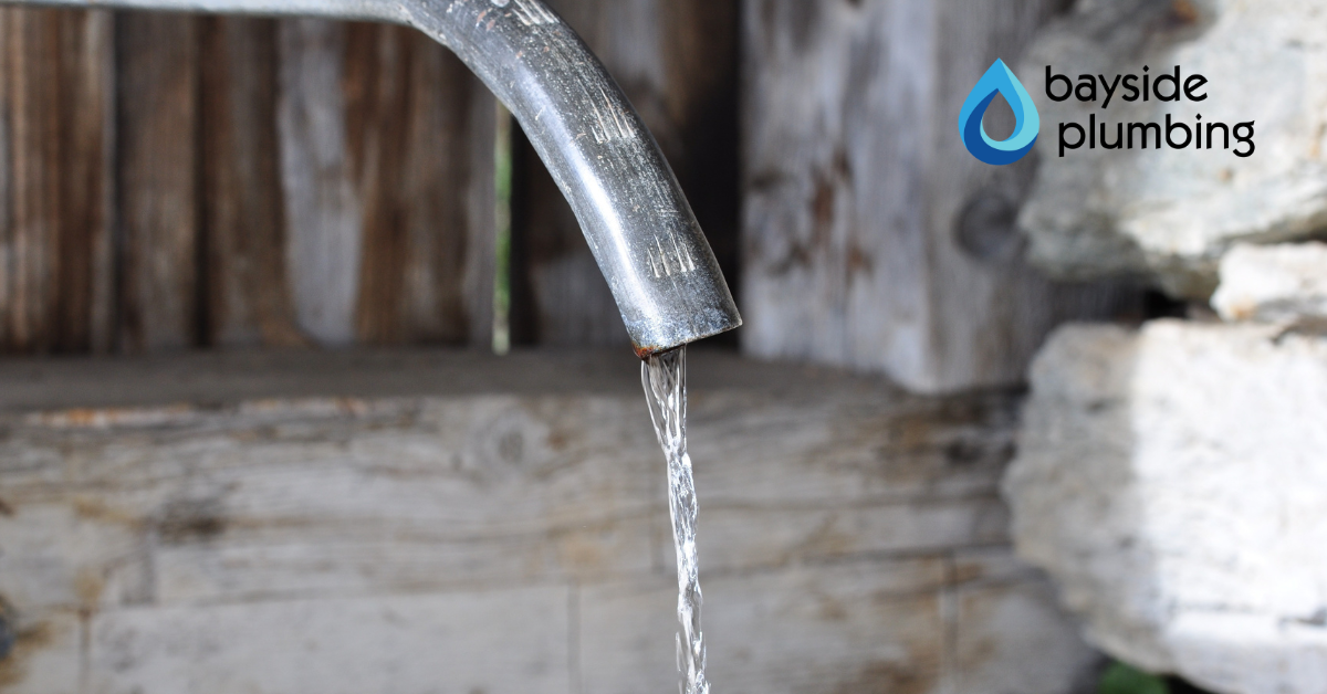 Leaking metal pipe dripping water showing need for pipe leak detection near me