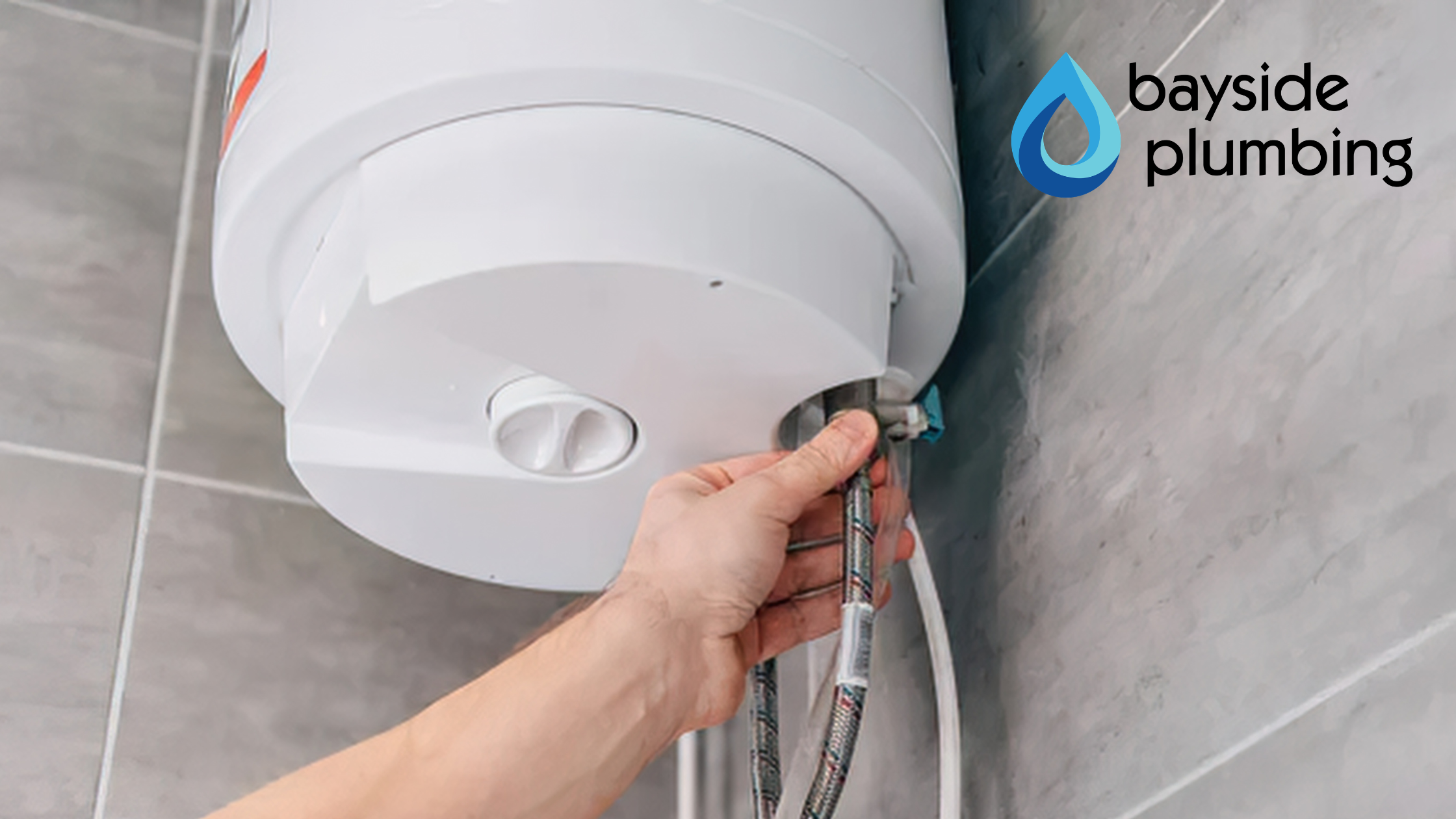 A professional plumber adjusting connections during a water heater installation on the Eastern Shore.