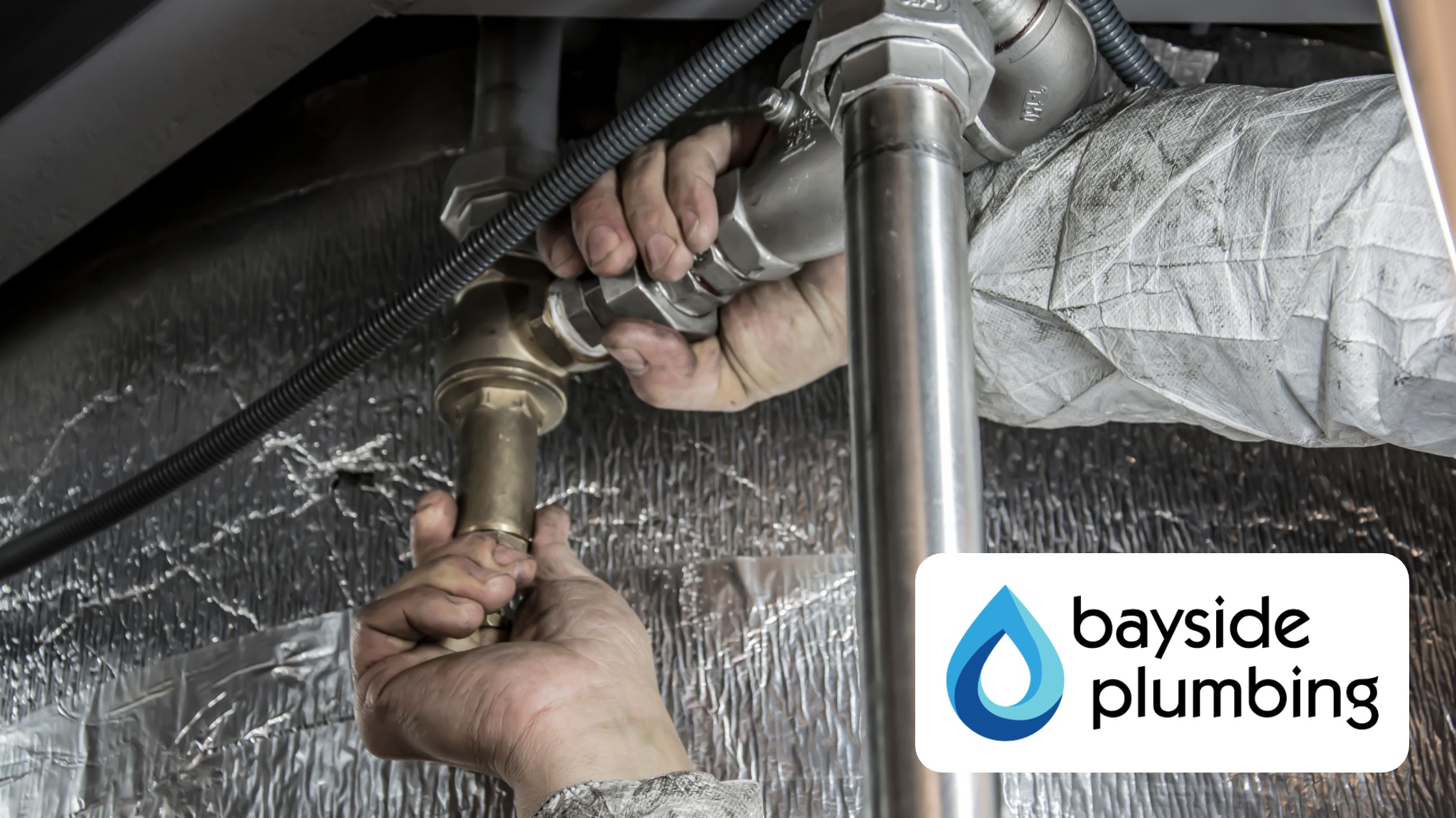 Bayside Plumbing technician servicing drain pipes under a sink in Spanish Fort AL